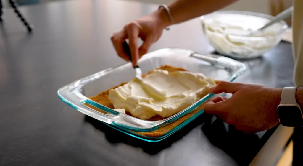 Creamy filling spread over graham cracker crust for Cherry Yum Yum