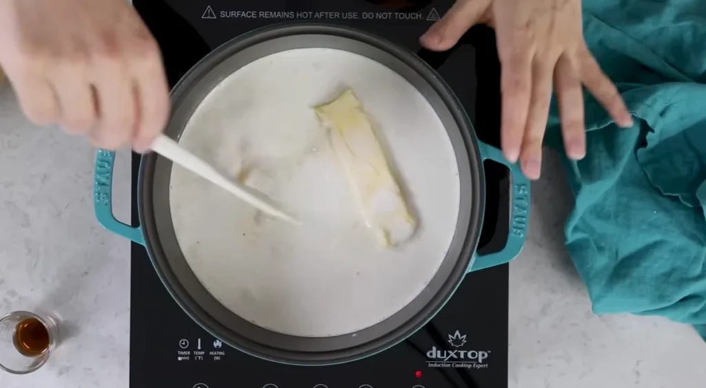 Butter stirred into the warm dairy and sugar mixture for homemade caramel candy