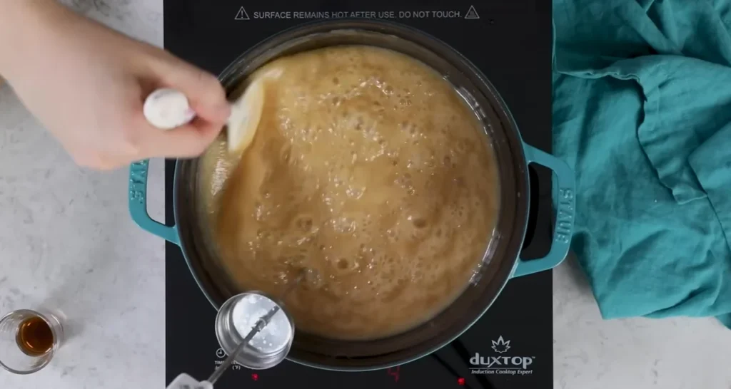 Caramel mixture bubbling in a saucepan as it cooks to the soft chewy stage