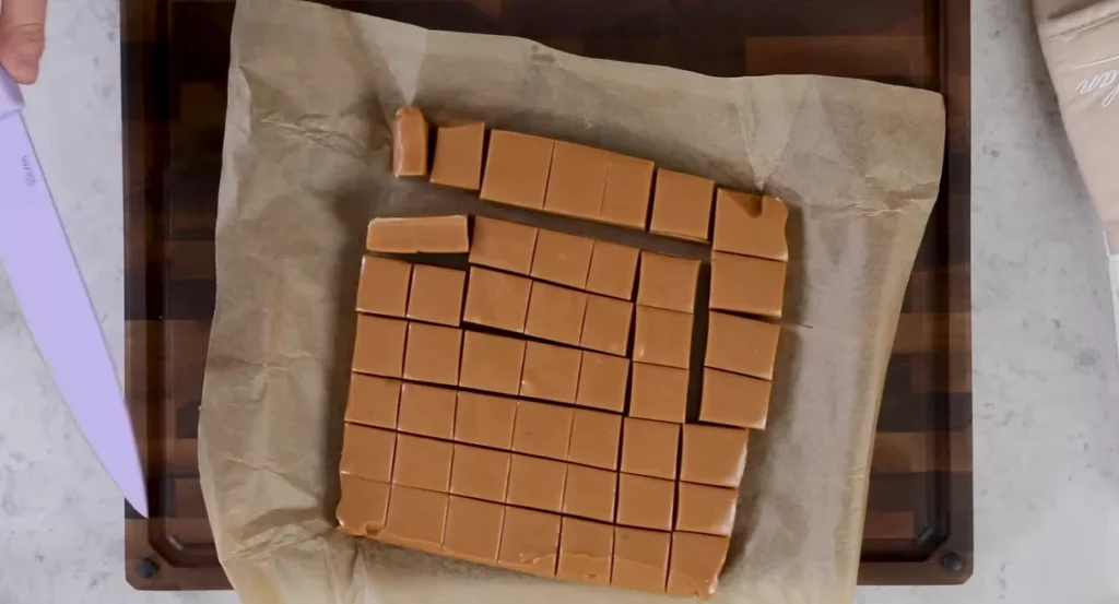 Chilled homemade caramel slab cut into individual soft chewy pieces