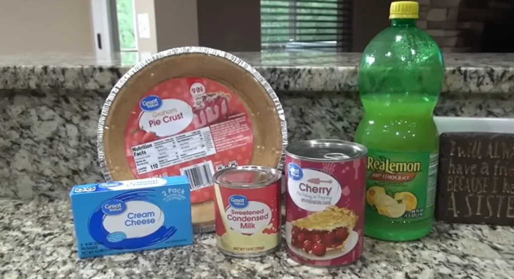 Cherry cream cheese pie ingredients with graham cracker crust, cream cheese, condensed milk, lemon juice, and cherry pie filling