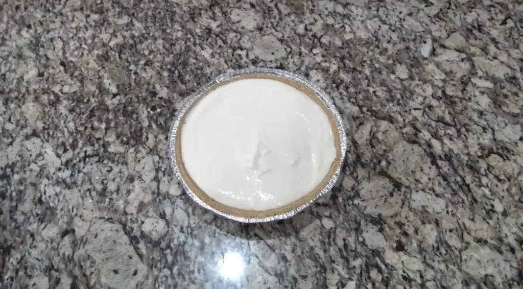Cream cheese filling spread into prepared graham cracker crust for cherry cream cheese pie