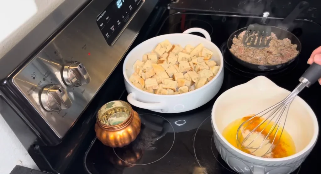 Pouring egg mixture over English muffins for Eggs Benedict Casserole