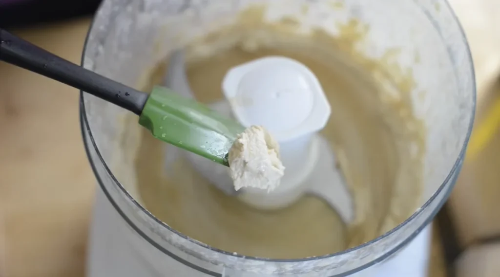 Whipped tahini and lemon mixture showing the creamy base for smooth homemade hummus.