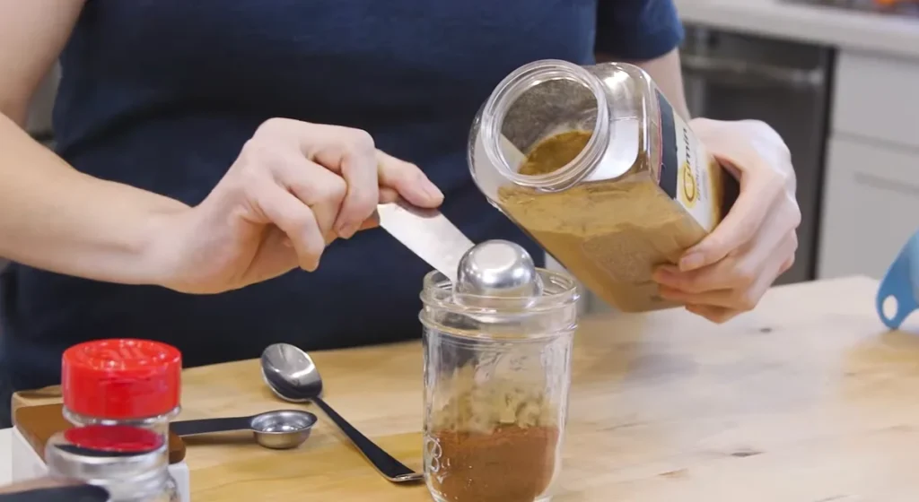 Homemade taco seasoning spices being mixed in a jar