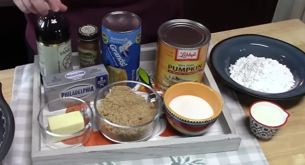 Pumpkin spice monkey bread ingredients including biscuit dough, pumpkin puree, butter, brown sugar, pecans, and spices