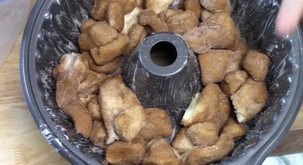 Pumpkin spice coated biscuit pieces arranged in a greased Bundt pan