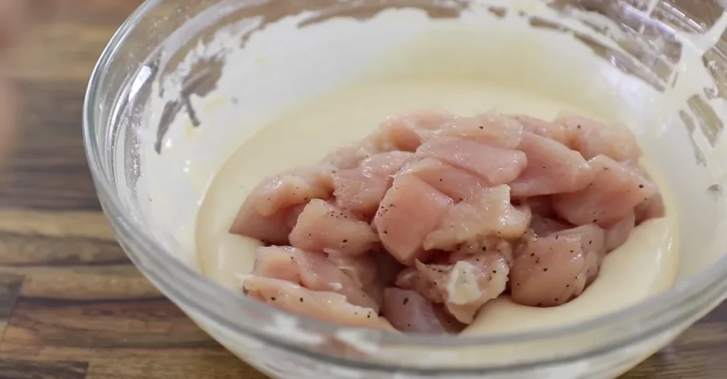 Chicken pieces coated in egg mixture for sesame chicken
