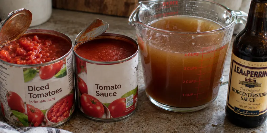 The tomato base ingredients lined up – diced tomatoes, tomato sauce, beef broth, and Worcestershire sauce
