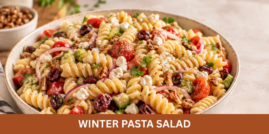 Finished Winter Pasta Salad served in a simple bowl with colorful pasta and visible fresh ingredients on a neutral surface.