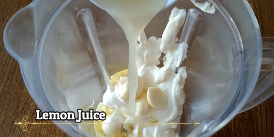 Fresh lemon juice being poured into the creamy shawarma sauce mixture