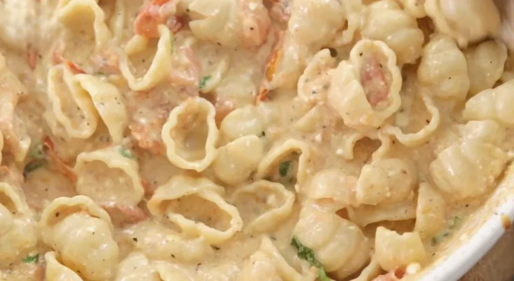 Creamy baked feta pasta shells coated in tomato and feta sauce with fresh herbs