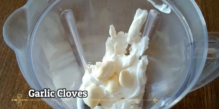 Peeled fresh garlic cloves on top of a creamy sauce base before mixing
