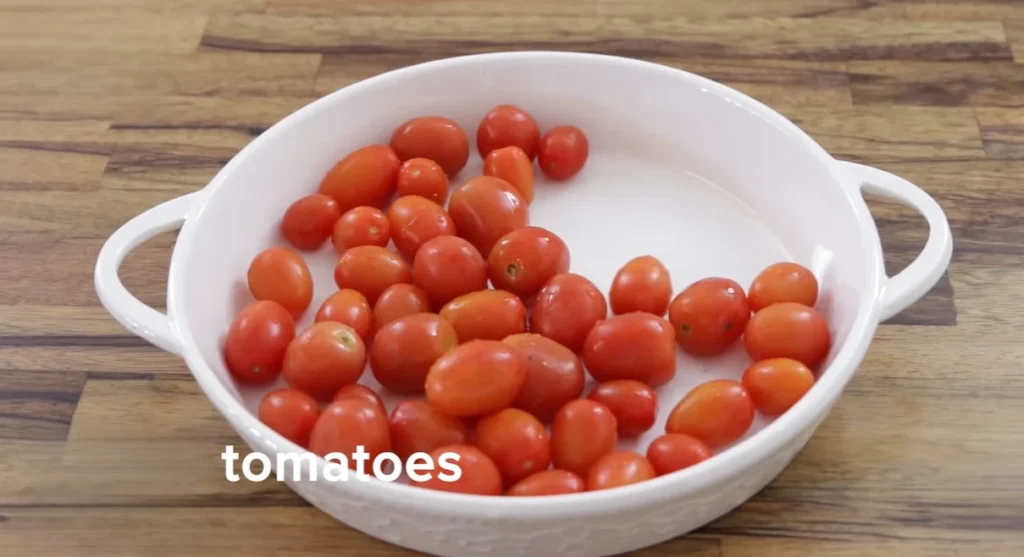 Fresh cherry tomatoes in a white baking dish on a wooden counter