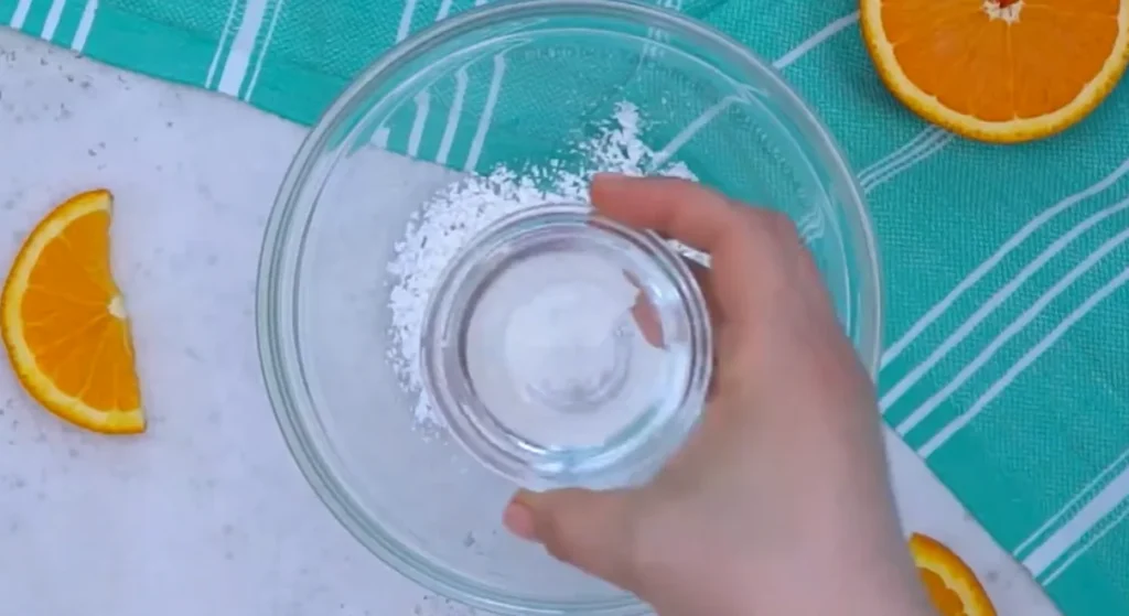 Pouring cold water into a bowl of cornstarch to make a slurry