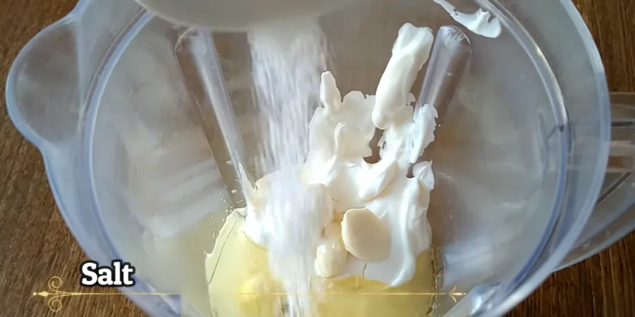 Fine salt being sprinkled into the shawarma sauce ingredients