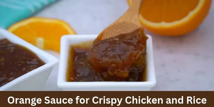 Homemade orange sauce in a white square bowl with a wooden spoon lifting thick, glossy sauce